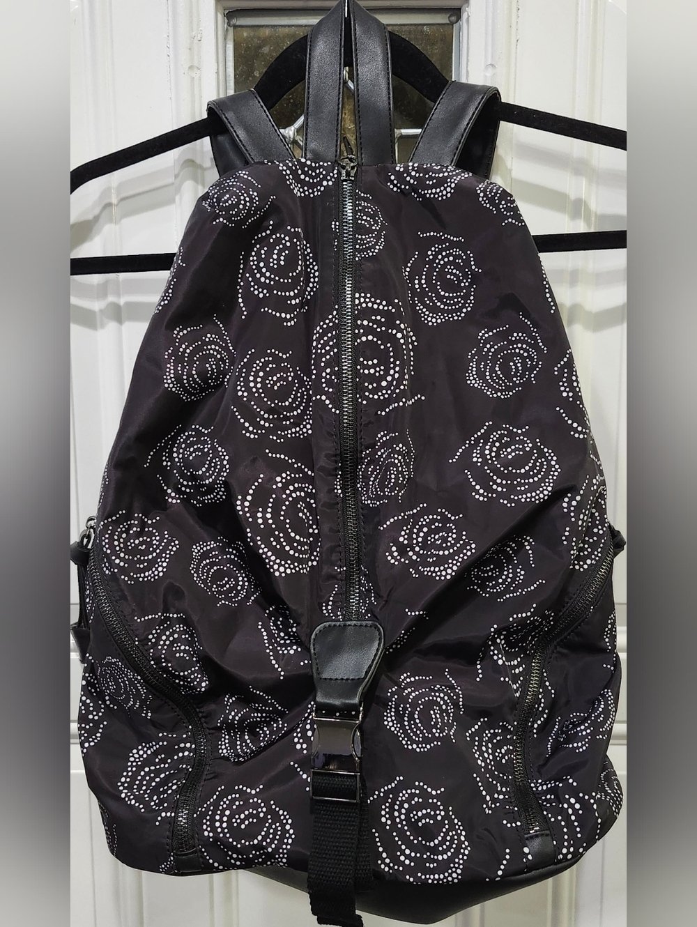 Fabletics The Row Backpack in black with a white digital roses pattern. 